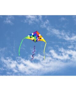 A wide shot of the HQ DELTA RAINBOW CHECKER 2M kite flying gracefully in a blue sky with scattered clouds.