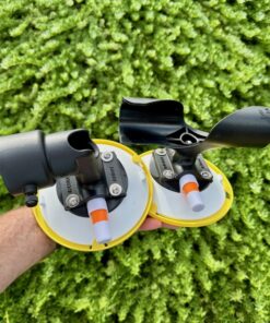 A hand holding the complete RV Flag Pole Buddy Suction Cup Mount 2.0 kit, showing both the upper "TWIST" mount and the lower "CUP" mount.