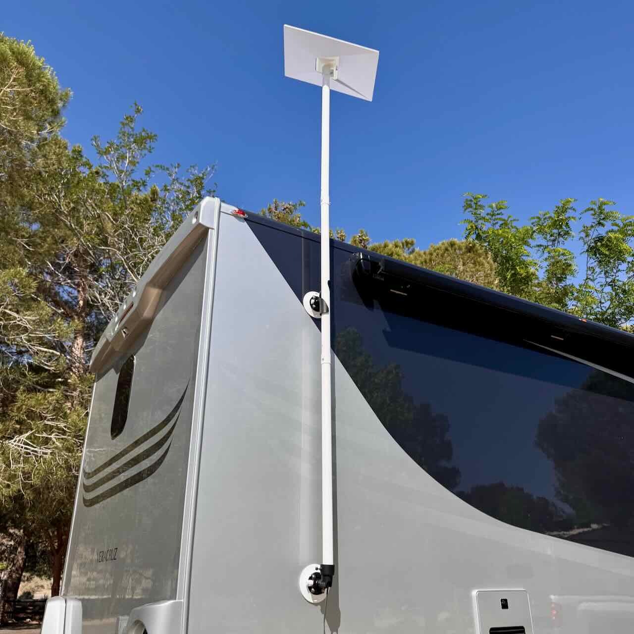 Full view of the RV Flag Pole Buddy Suction Cup Mount 2.0 kit holding a Starlink dish high above a modern silver motorhome, demonstrating a damage-free installation.