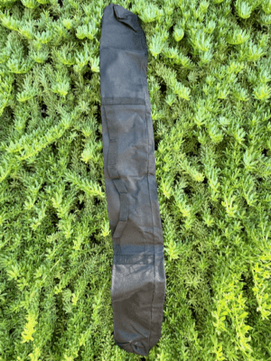 Full view of the black Starlink RV Pole Bag laying flat on green grass showing the shoulder strap