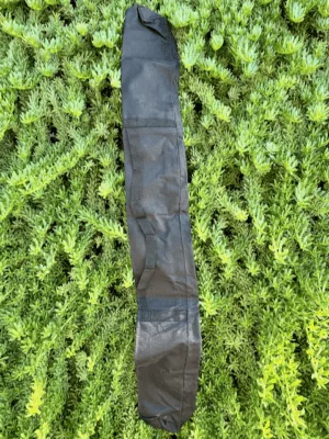 Full view of the black Starlink RV Pole Bag laying flat on green grass showing the shoulder strap