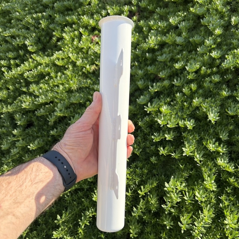 A hand holding the vertical tube of an RV Flag Pole Ramp Mount showing the flared top entry.