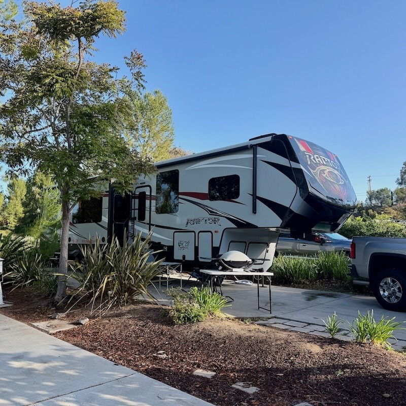 Side view of a toy hauler with a secure Starlink RV setup for resorts, perfectly positioned to clear nearby trees.